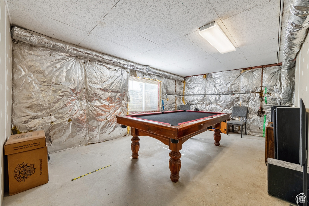 Rec room with pool table, unfinished concrete floors, and a paneled ceiling