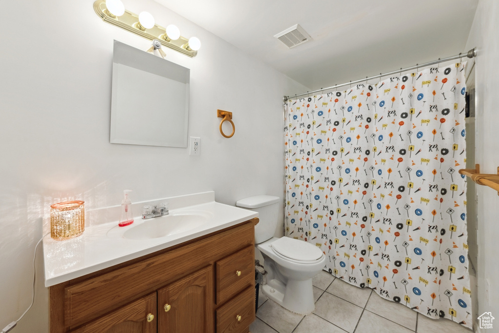 Full bathroom with tile patterned floors, vanity, and curtained shower