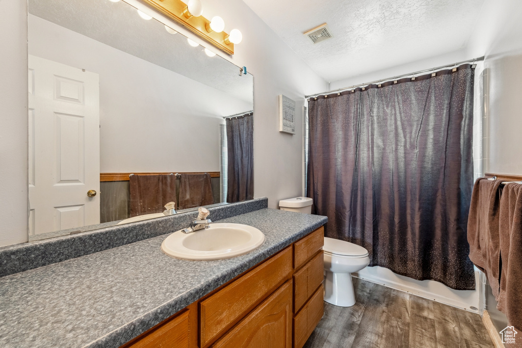 Bathroom featuring vanity, wood finished floors, and shower / tub combo
