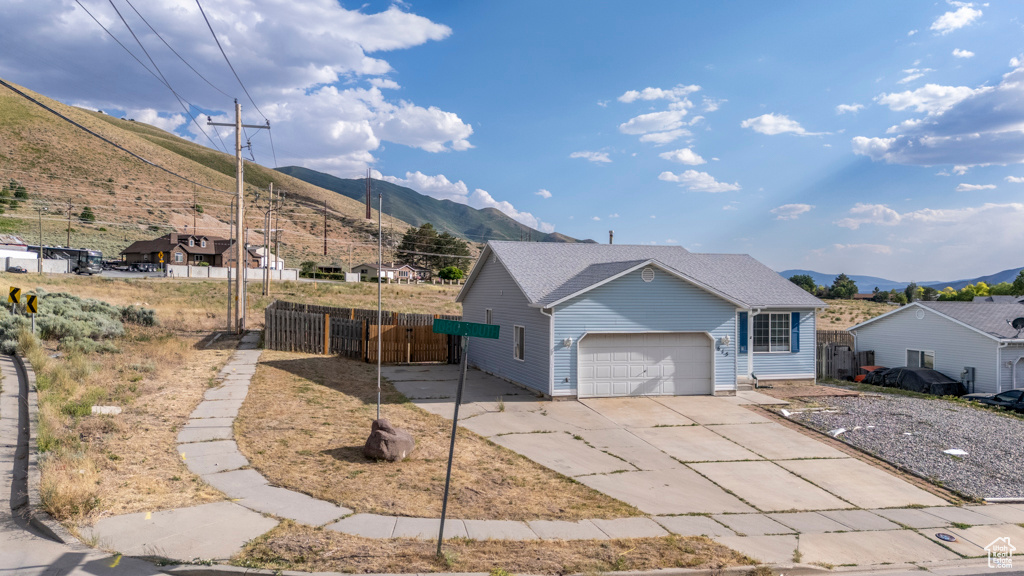 View of front of property featuring a mountain view, a garage, and concrete driveway