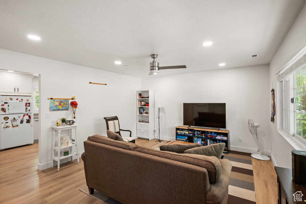 Living room with light wood-style floors, recessed lighting, and ceiling fan