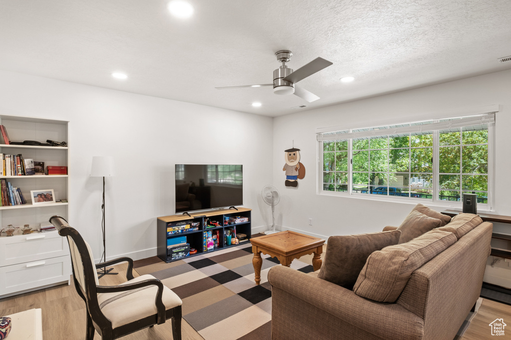 Living room featuring ceiling fan, light wood-type flooring, and recessed lighting