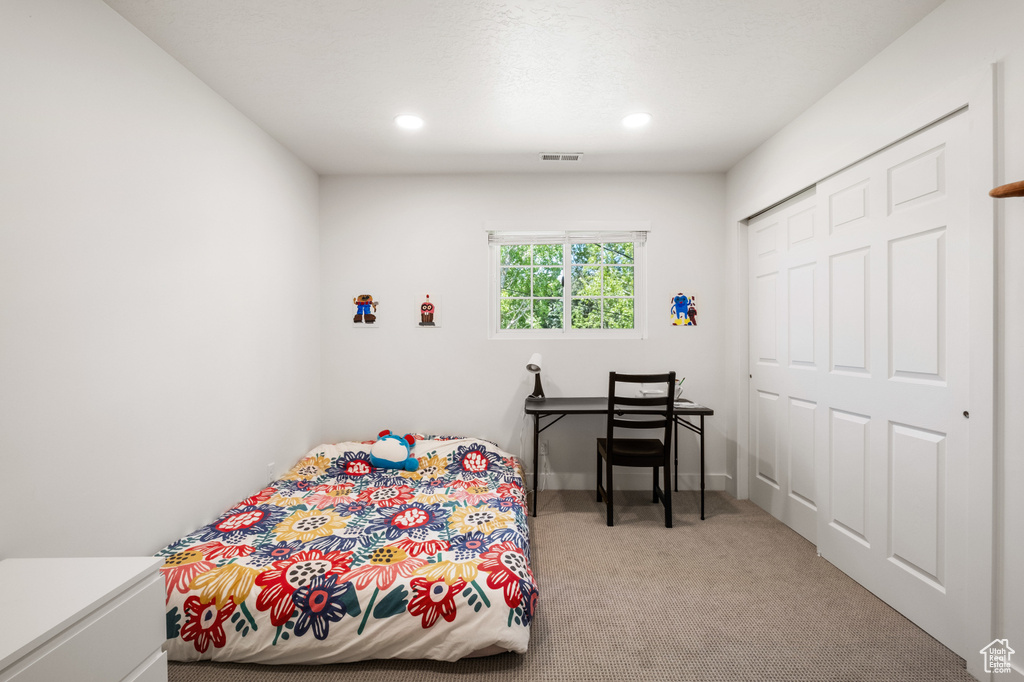 Bedroom with carpet floors, recessed lighting, and a closet