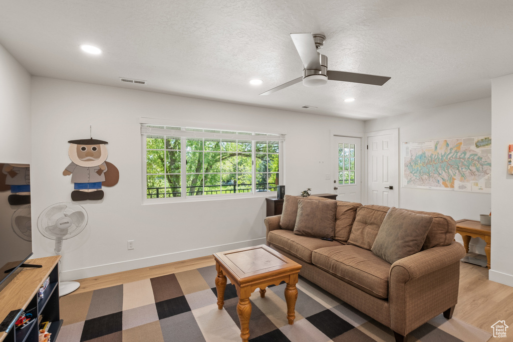 Living room featuring light wood-style flooring, recessed lighting, and a ceiling fan