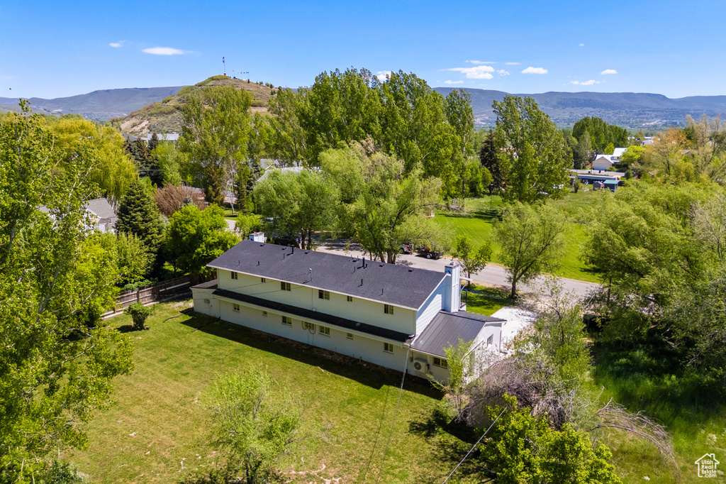 Aerial view of property and surrounding area featuring a mountainous background