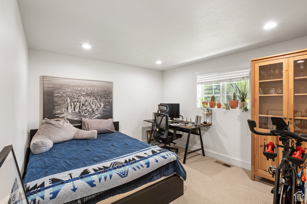 Bedroom featuring light colored carpet, recessed lighting, and a desk