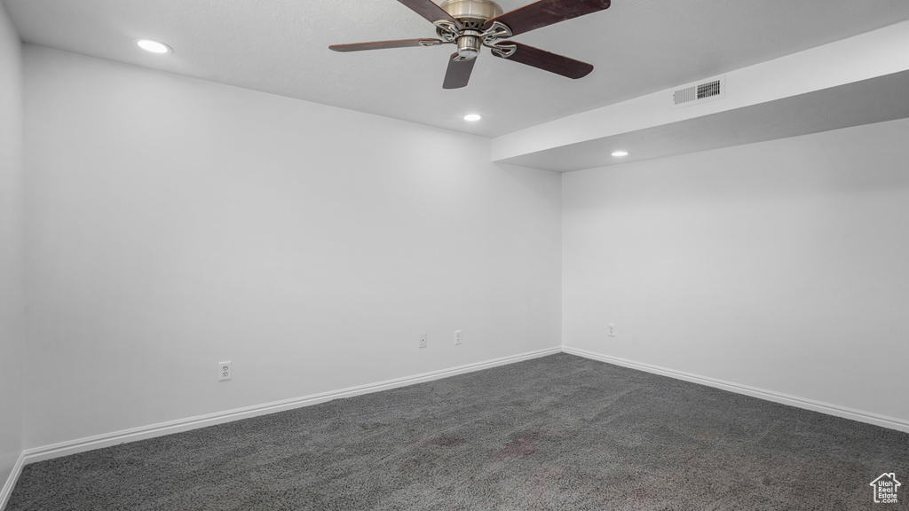 Spare room featuring recessed lighting, dark colored carpet, and a ceiling fan