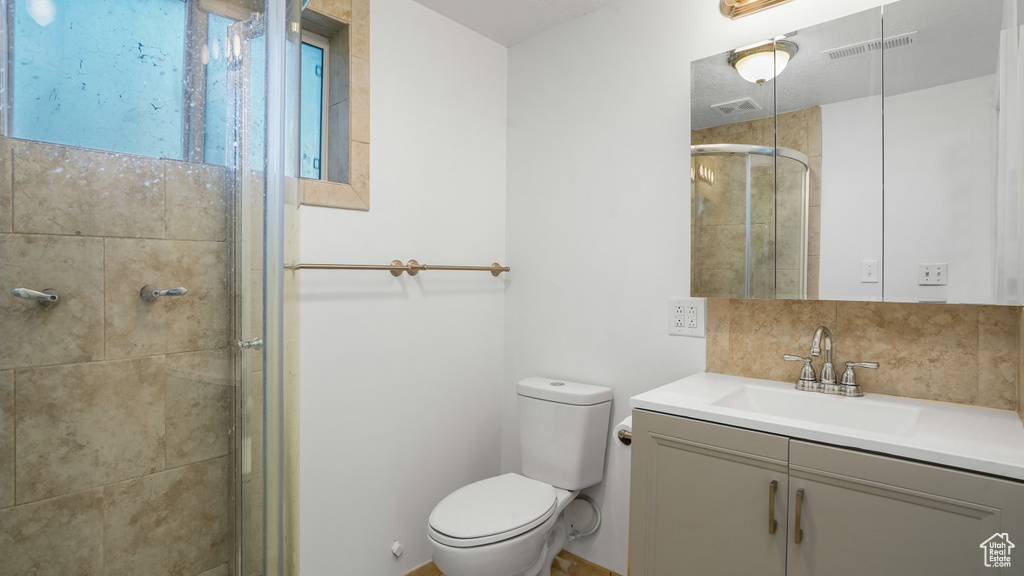 Full bathroom with vanity, a stall shower, and decorative backsplash