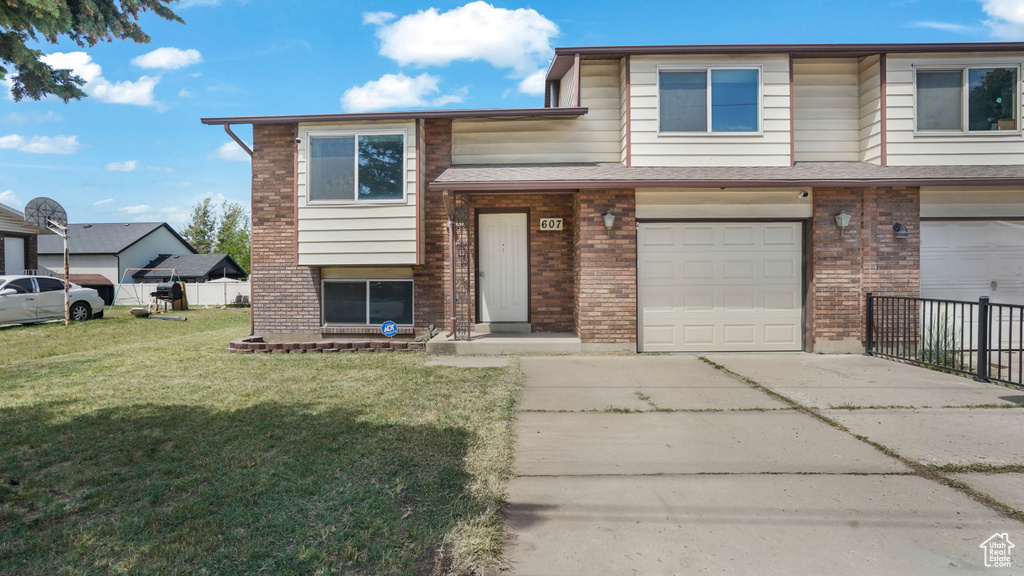 View of front of house featuring concrete driveway, brick siding, and an attached garage