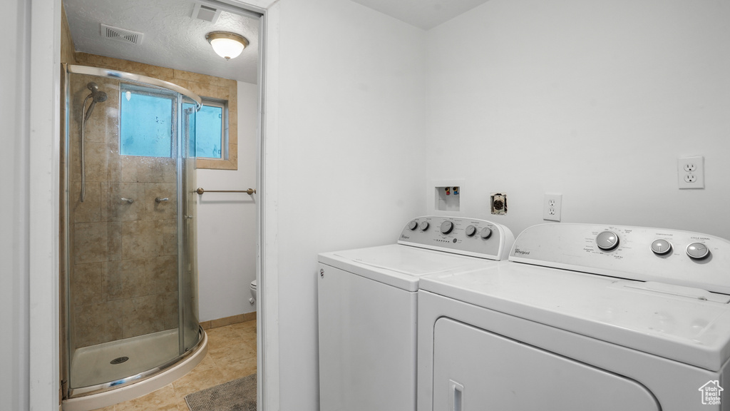 Laundry room featuring independent washer and dryer and light tile patterned floors