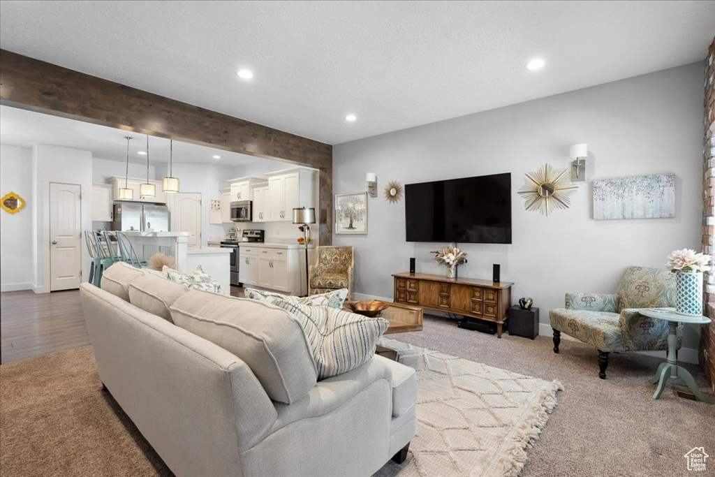 Living area featuring recessed lighting, beam ceiling, and light colored carpet
