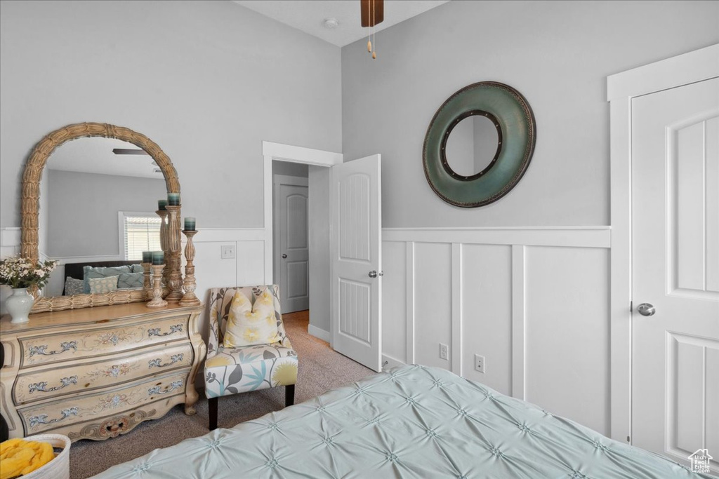 Bedroom with a wainscoted wall, carpet flooring, and a decorative wall