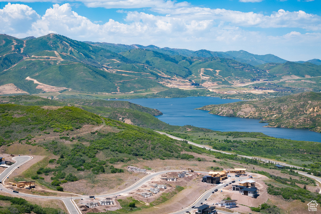 Aerial view of property and surrounding area with a water and mountain view