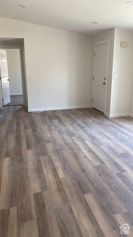 Spare room featuring dark wood-style floors and a textured ceiling
