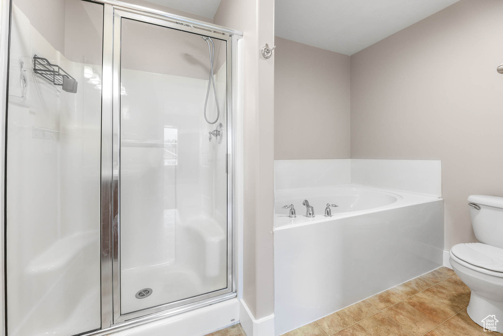 Full bath featuring a shower stall, a garden tub, and tile patterned floors