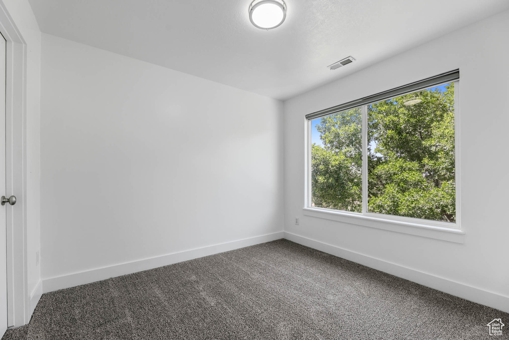 Spare room featuring carpet and baseboards