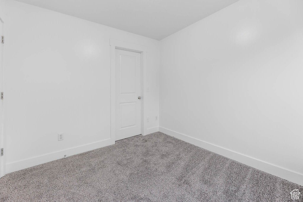 Spare room featuring carpet floors and baseboards