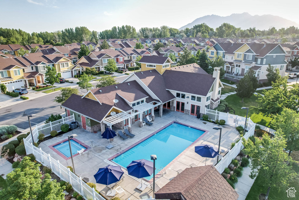 Community pool featuring a residential view, a fenced backyard, a pergola, and a mountain view