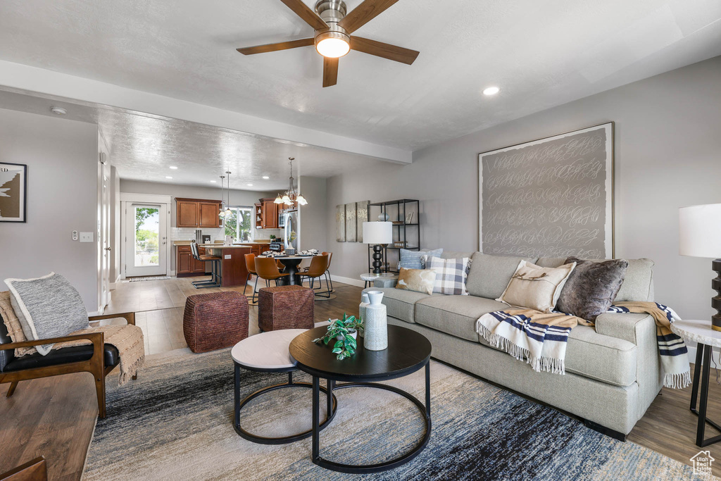 Living room with ceiling fan, a chandelier, light wood-style flooring, and recessed lighting