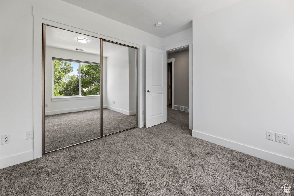 Unfurnished bedroom with carpet flooring and a closet