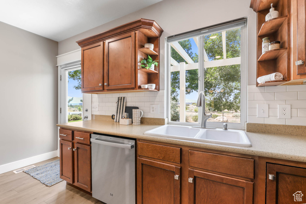 Kitchen with open shelves, dishwasher, light countertops, and backsplash