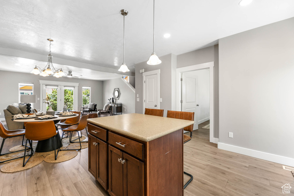 Kitchen featuring a kitchen breakfast bar, a center island, light wood-type flooring, recessed lighting, and open floor plan