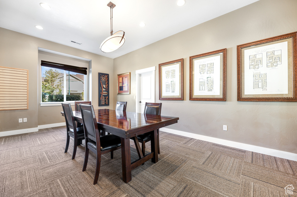 Carpeted dining space with baseboards and recessed lighting