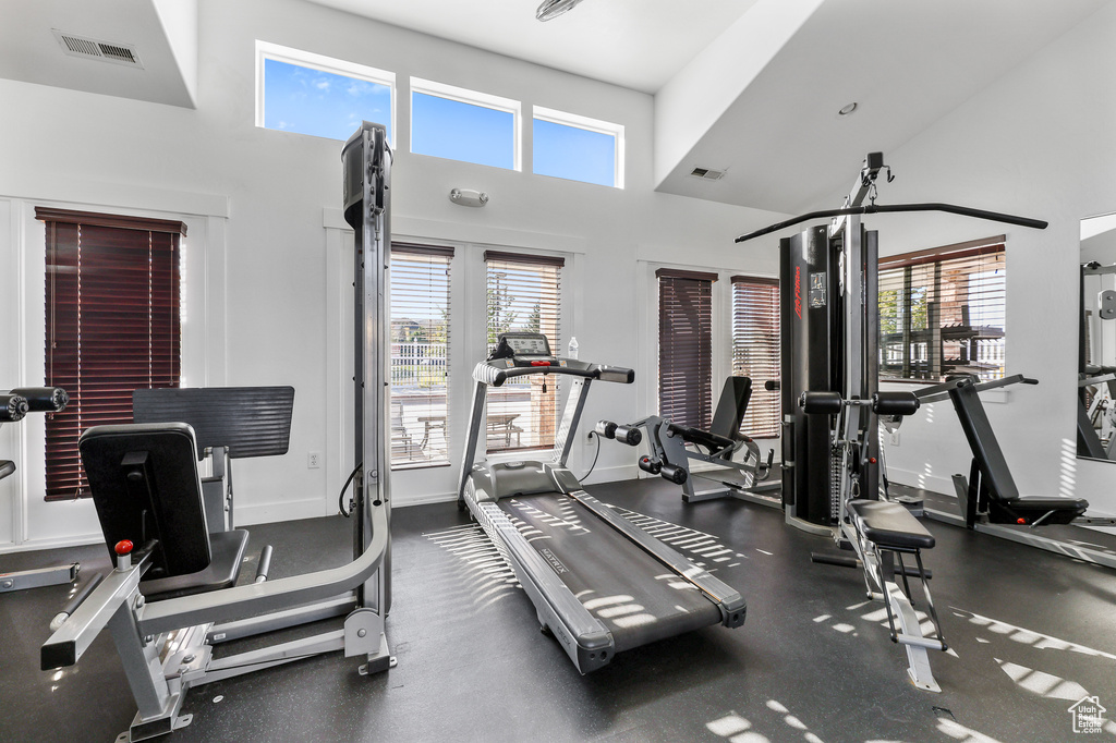 Gym featuring a high ceiling and baseboards