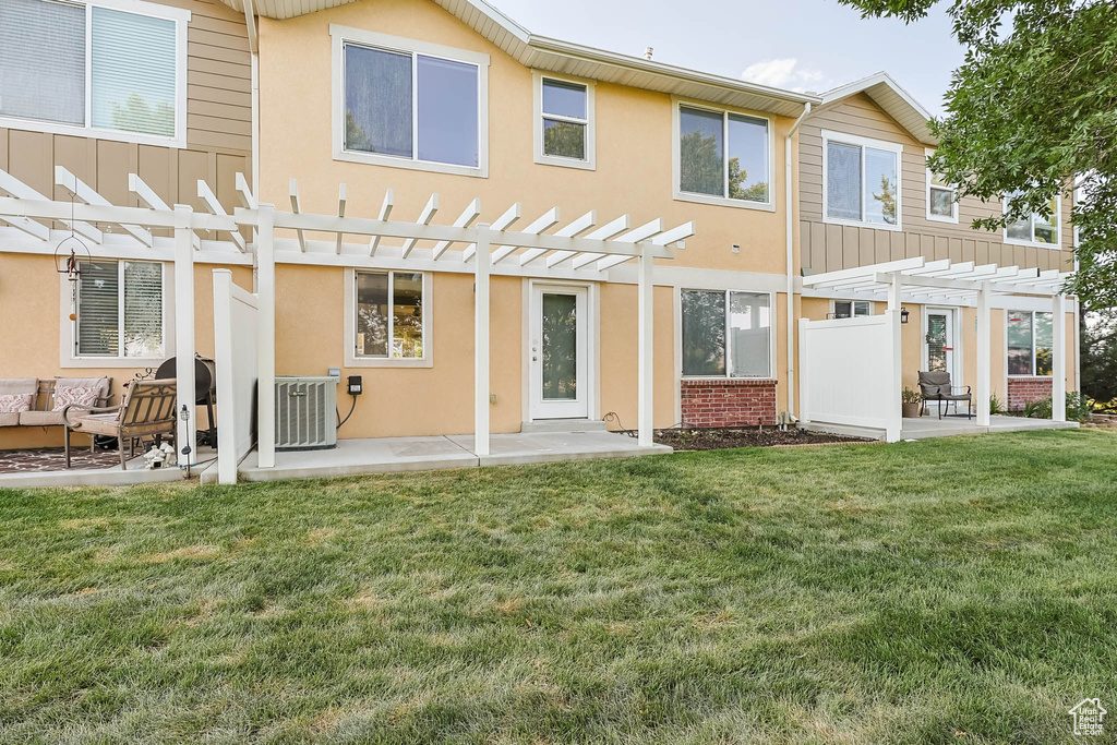 Rear view of property featuring a pergola, a patio, a yard, and an outdoor living space
