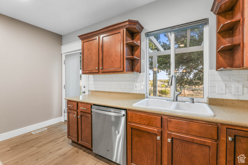 Kitchen with dishwasher, open shelves, light wood-style floors, and light countertops