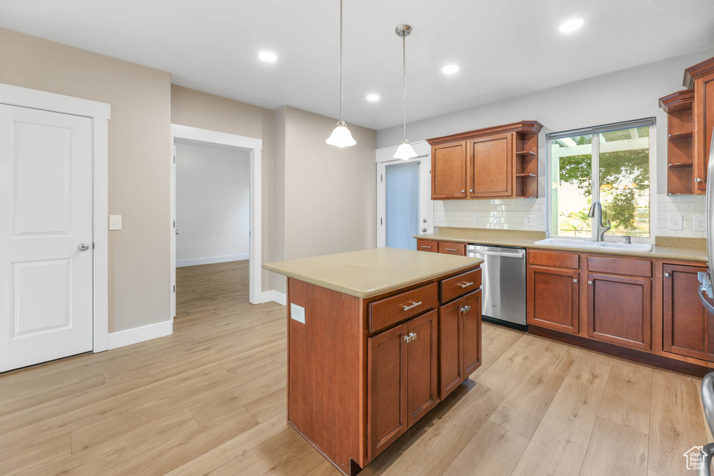 Kitchen featuring stainless steel dishwasher, open shelves, tasteful backsplash, light countertops, and light wood-style flooring