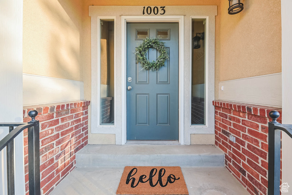 Doorway to property with stucco siding and brick siding