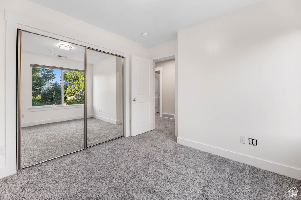 Unfurnished bedroom featuring carpet floors and a closet