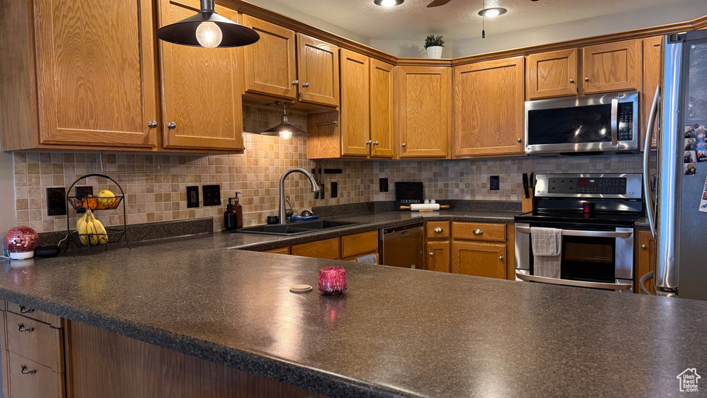 Kitchen featuring appliances with stainless steel finishes, dark countertops, and decorative backsplash