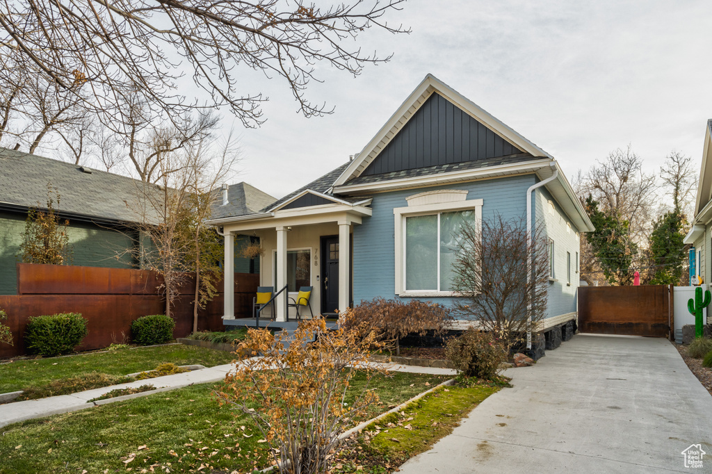 View of front of house with a porch, board and batten siding, and a shingled roof
