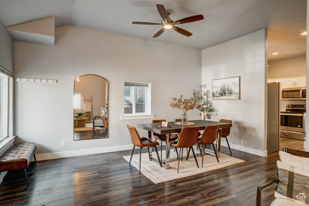 Dining room featuring ceiling fan, dark wood-style floors, vaulted ceiling, recessed lighting, and arched walkways