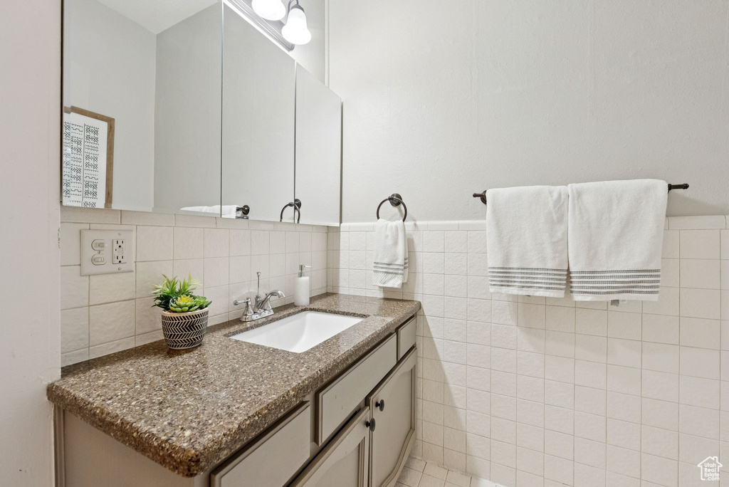 Bathroom with vanity and tile walls