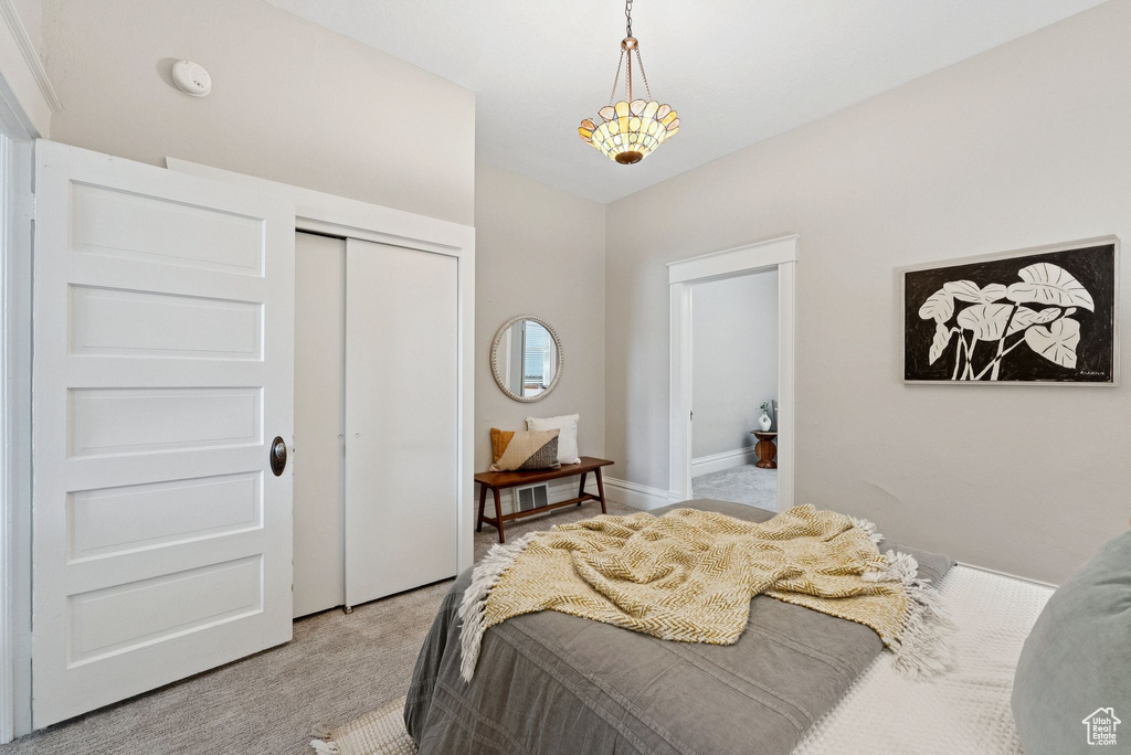 Bedroom featuring light colored carpet and a closet