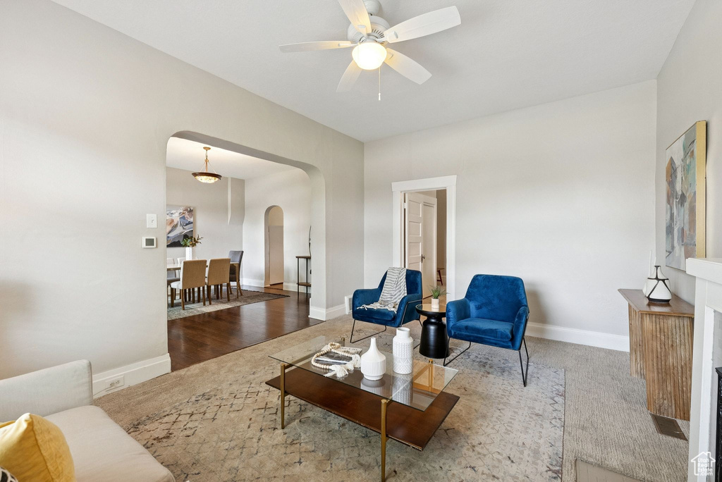 Living area with arched walkways and ceiling fan