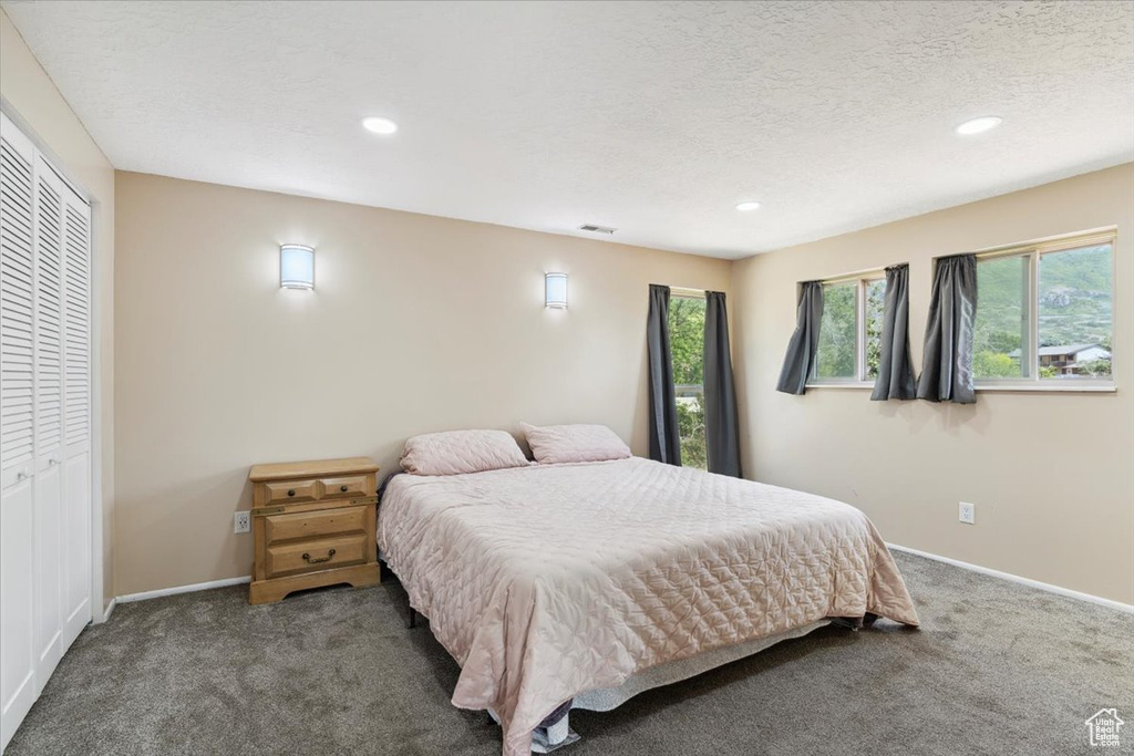 Bedroom with carpet floors, recessed lighting, and a textured ceiling