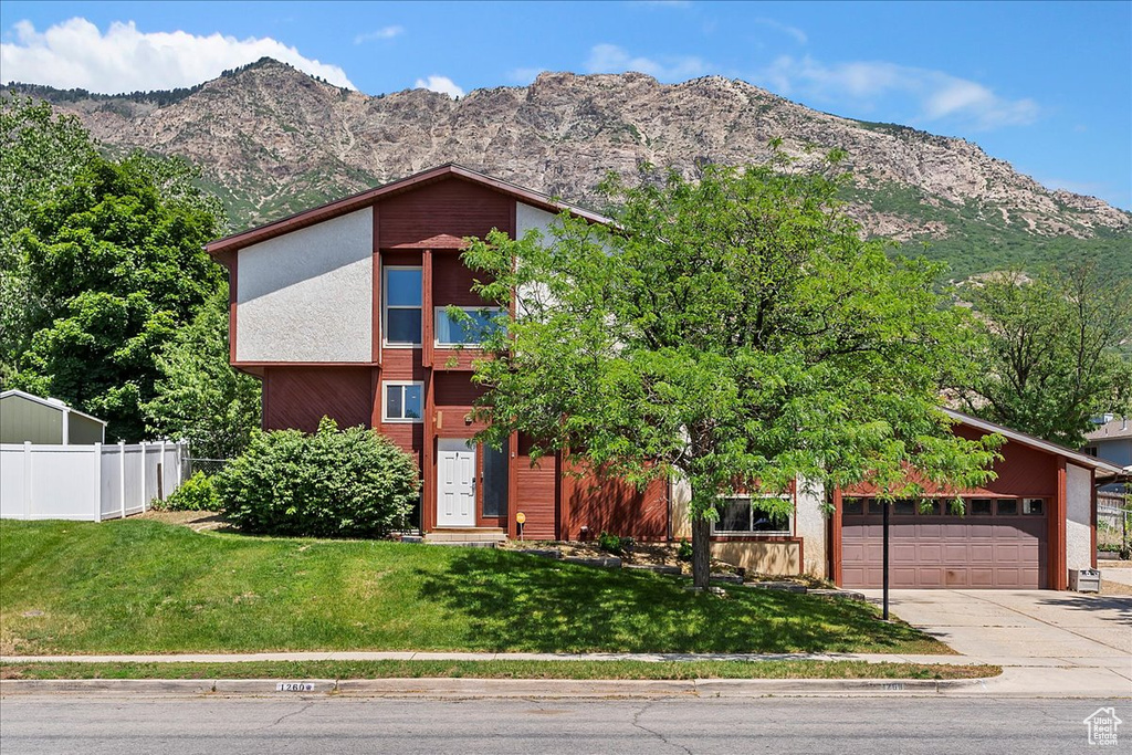 Mid-century inspired home with driveway, a mountain view, and an attached garage