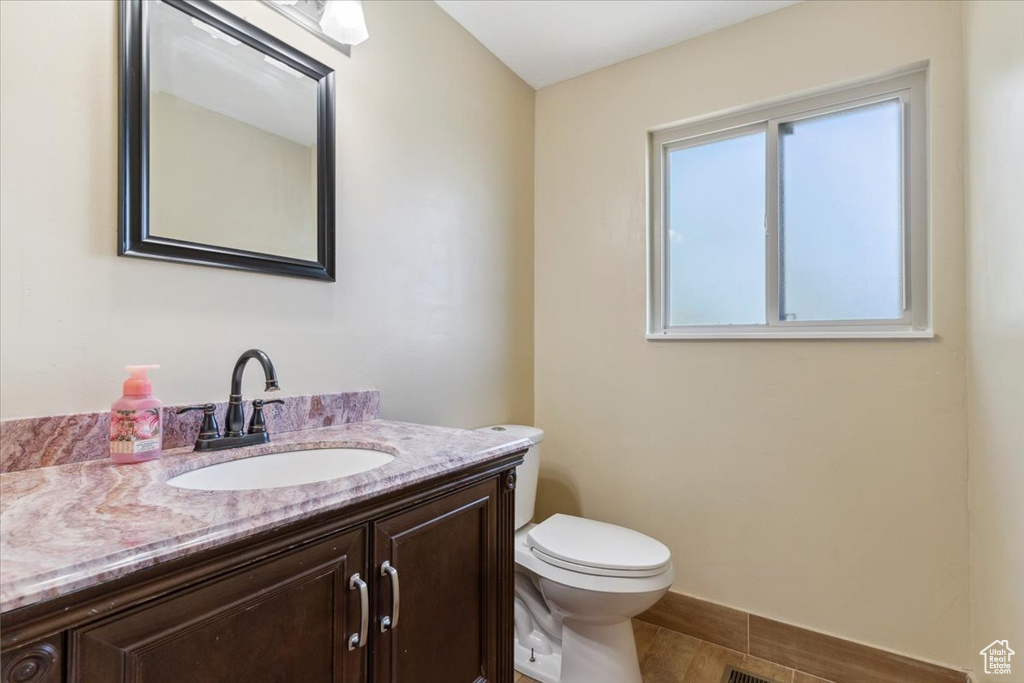 Half bathroom with vanity and toilet