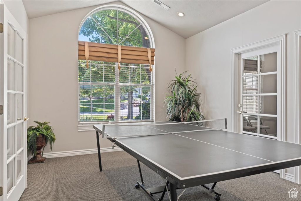 Recreation room with lofted ceiling, healthy amount of natural light, carpet floors, and french doors
