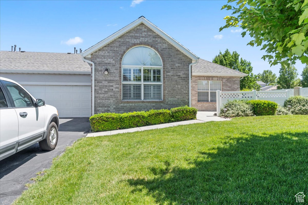 Ranch-style house with brick siding, an attached garage, and driveway