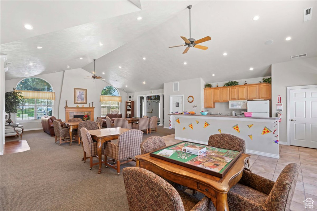 Dining room featuring a ceiling fan, recessed lighting, high vaulted ceiling, and a fireplace