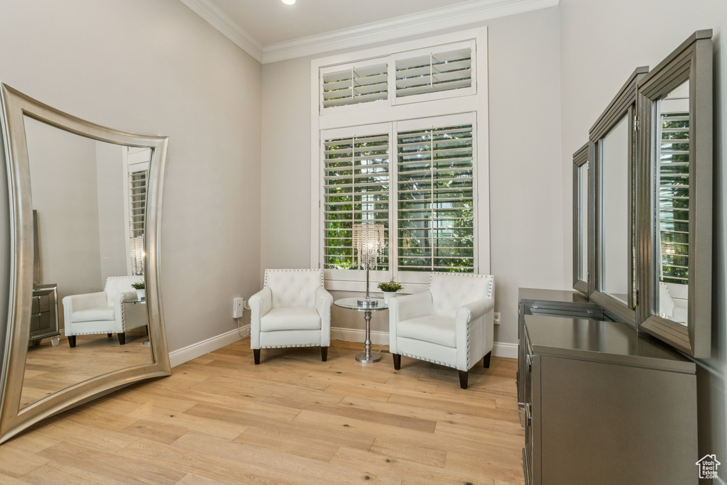 Living area featuring crown molding and light wood finished floors
