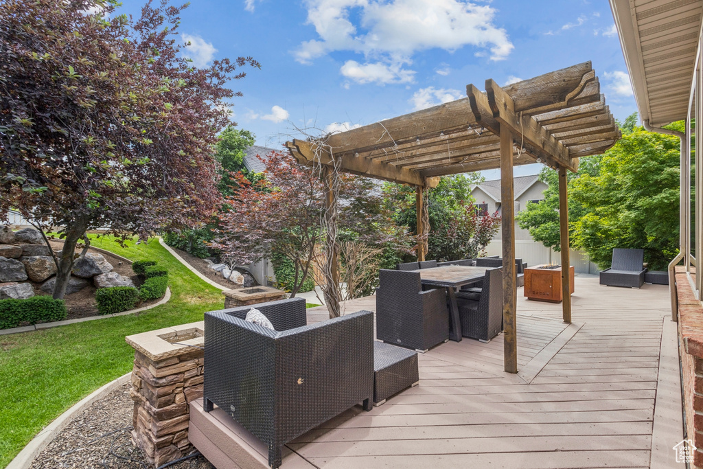 Wooden deck featuring a pergola and outdoor dining space