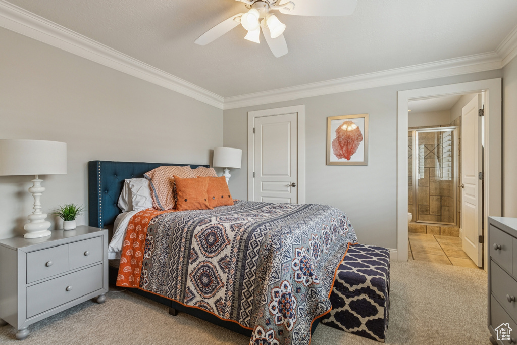 Bedroom with ornamental molding, light carpet, connected bathroom, and ceiling fan