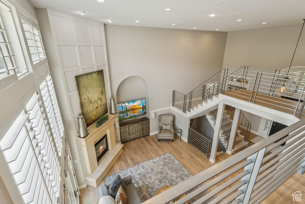 Living area with wood finished floors, a glass covered fireplace, and recessed lighting