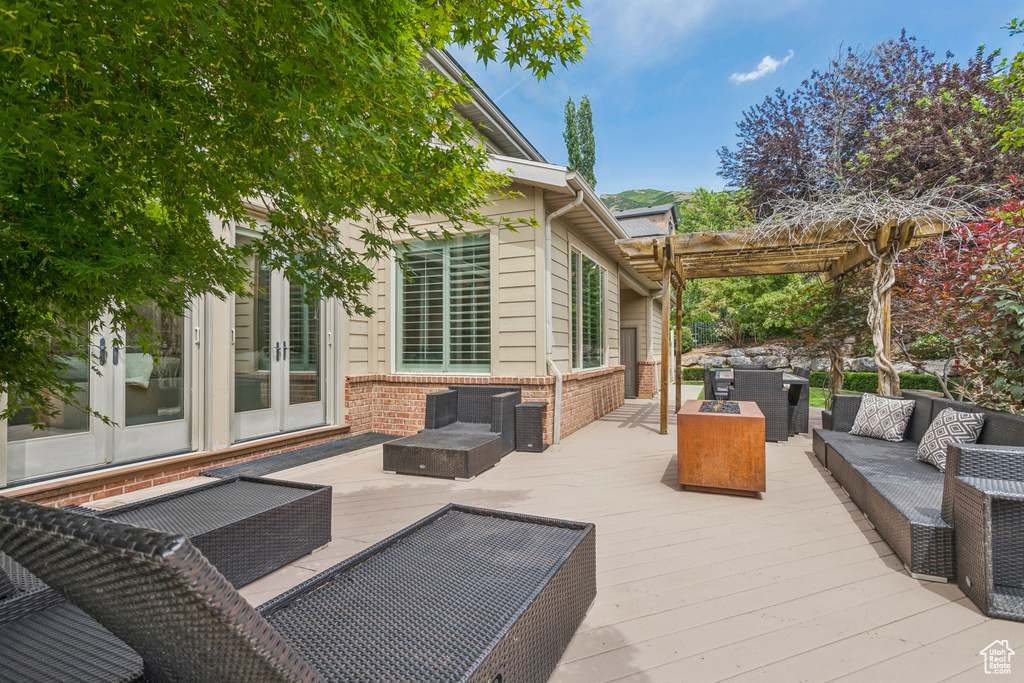 Deck featuring french doors, an outdoor hangout area, and a pergola